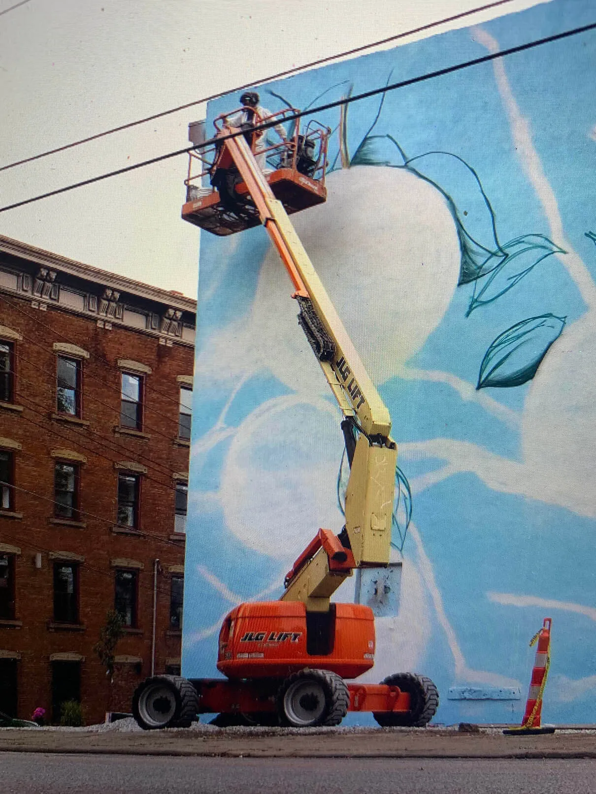Early stage: a boom lift in front of the wall with the first outlines on a blue background