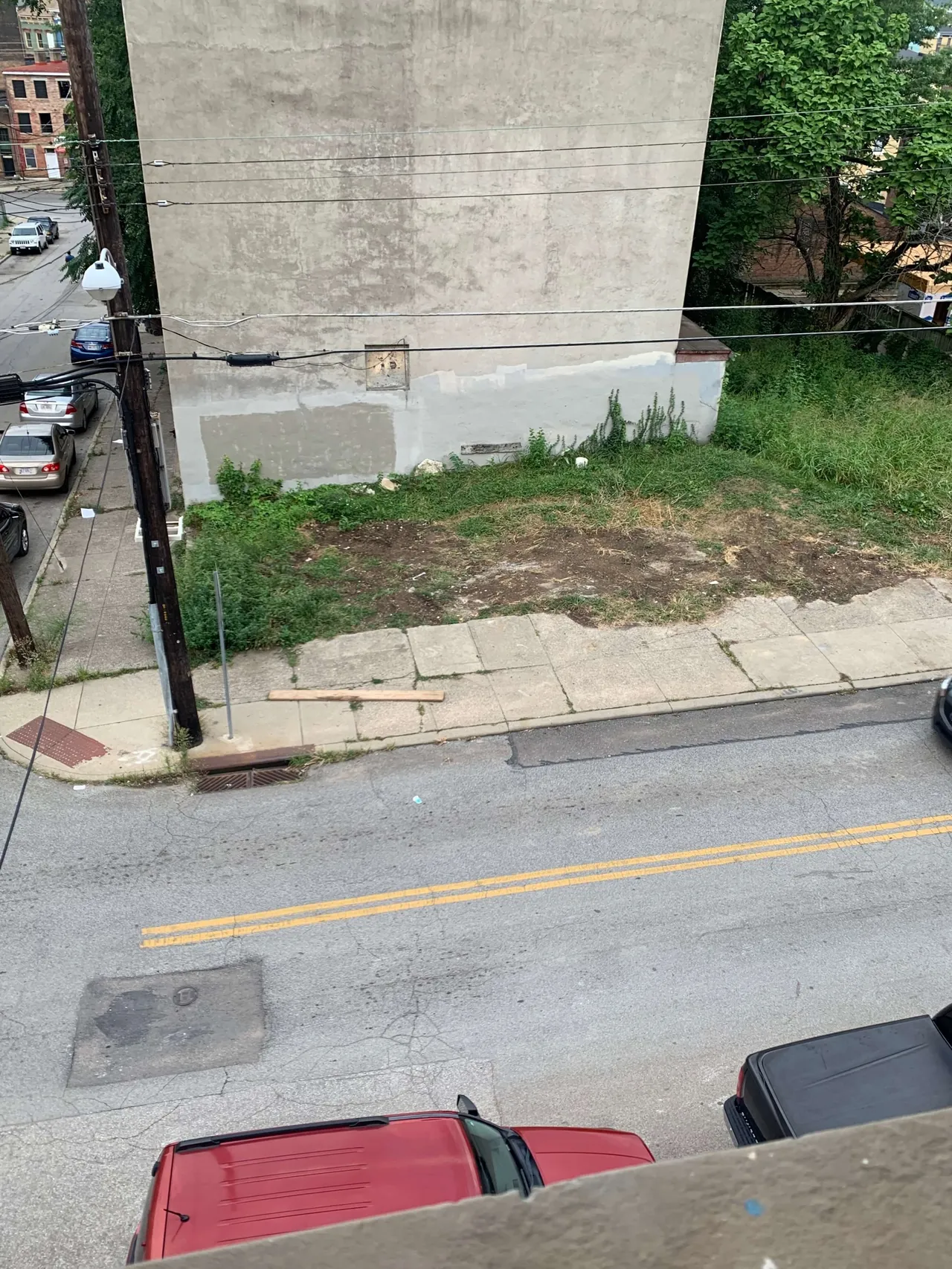 The blank concrete wall above an empty lot, before the mural was painted