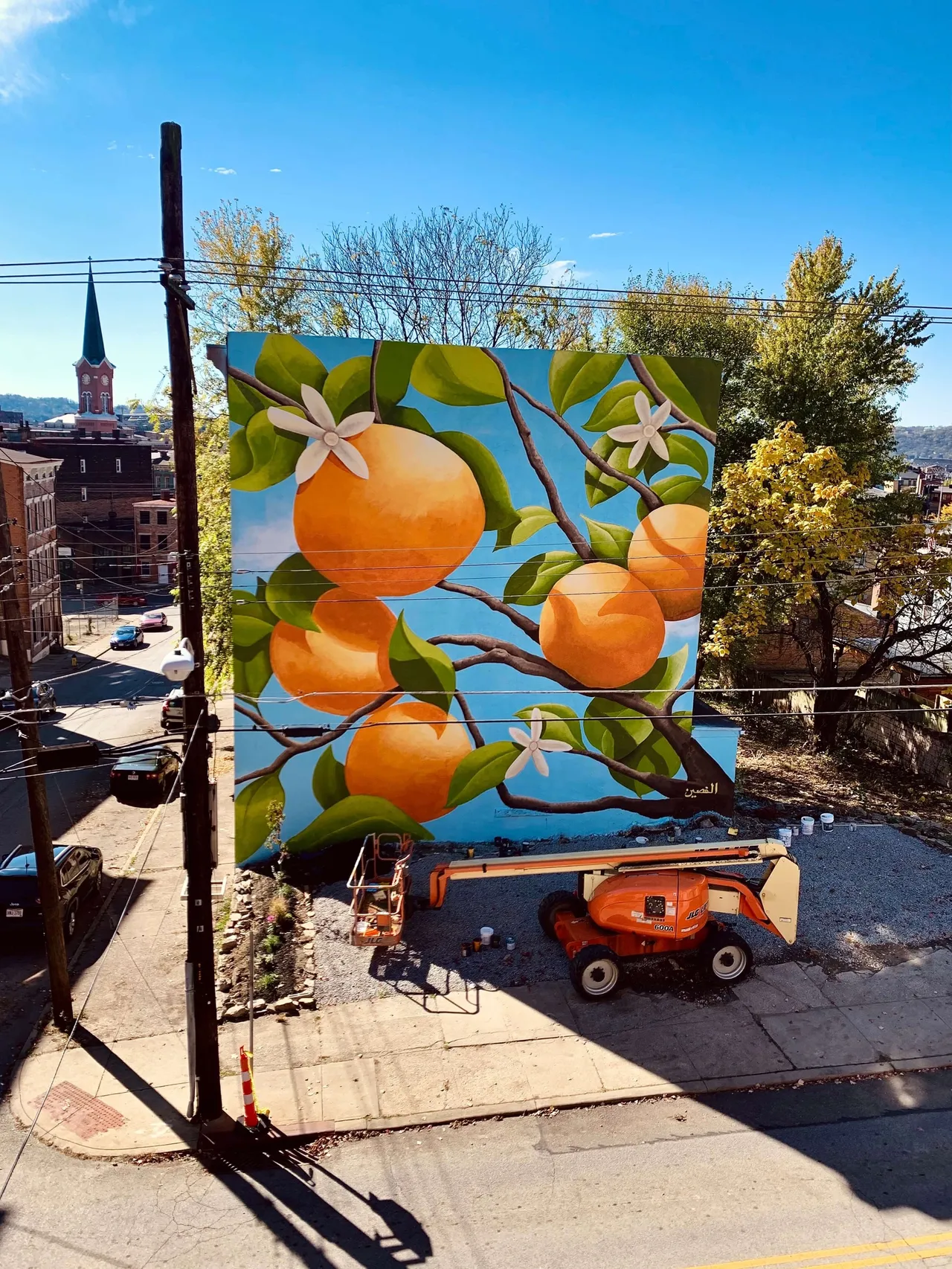 The finished mural seen from above, with a boom lift parked beside it