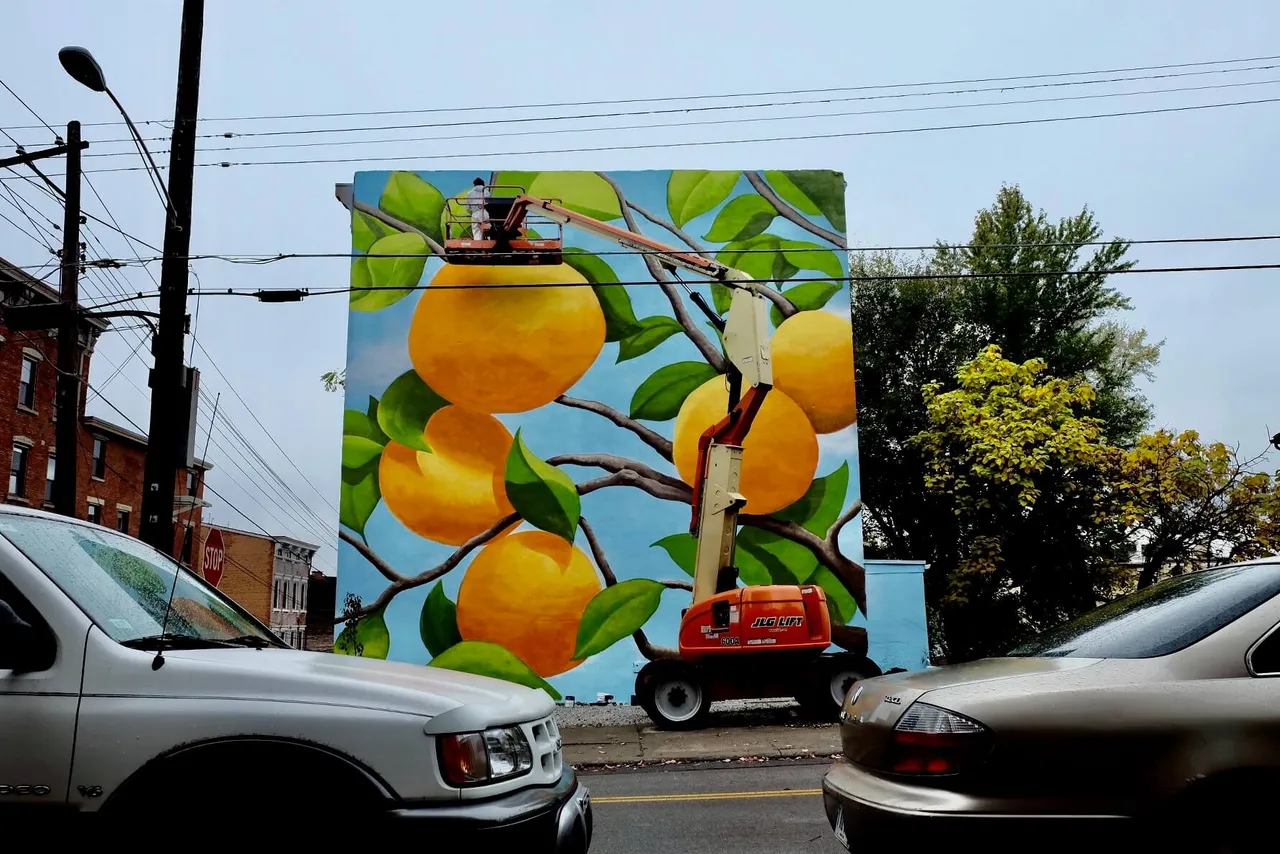 The finished mural seen from the street, with parked cars in front